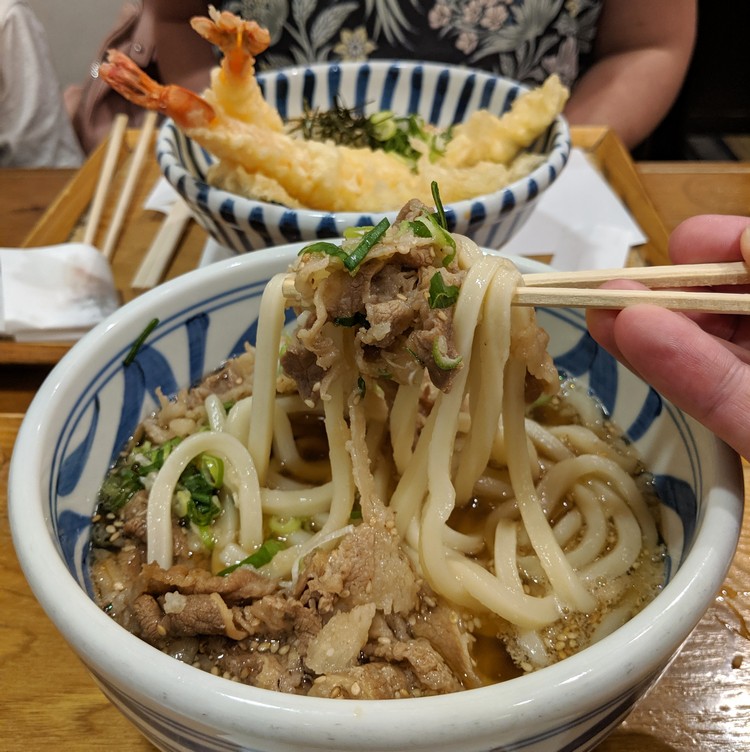 bowl of udon noodle soup with beef served in Tokyo Japan, with tempura udon Japanese cuisine