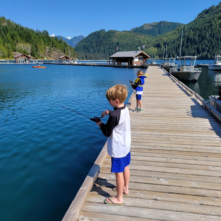 kids fishing on the dock at Moutcha Bay Marina in Nootka Sound on west coast of Vancouver Island, British Columbia