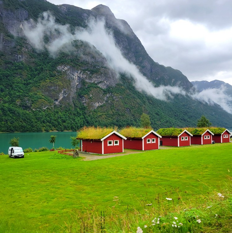 red cabins with grass roofs at Gryta Camping Oldevatnet lake