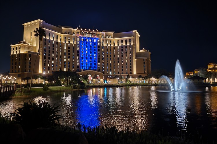 main hotel at Disney's Coronado Springs Resort at night, with lights and fountain and lake
