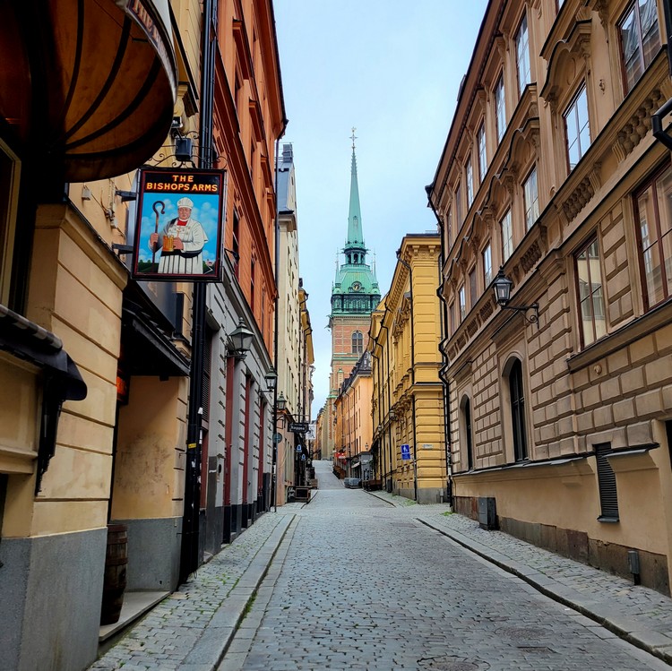 Old town Stockholm streets in the morning, Gamla Stan streets and old church with green spire called The German Church