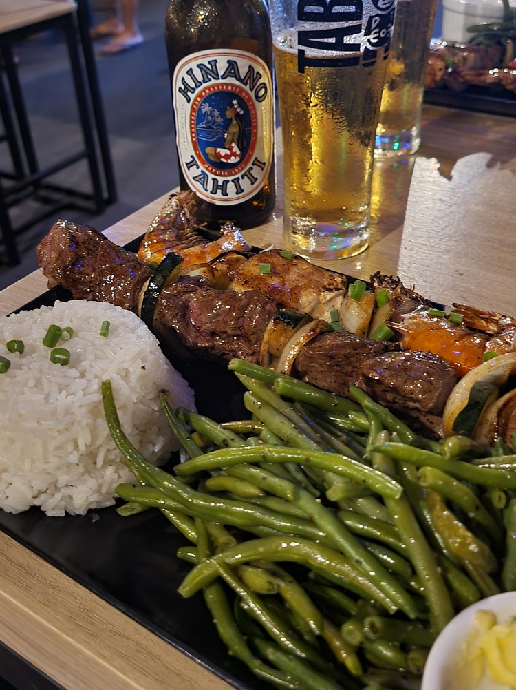 Grilled beef and seafood skewers with rice and green beans at Manuia Grill on Moorea Island, restaurant located across the street from Manava Moorea resort