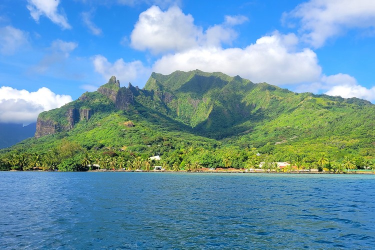 view of Moorea island from the water. lush green volcano landscape